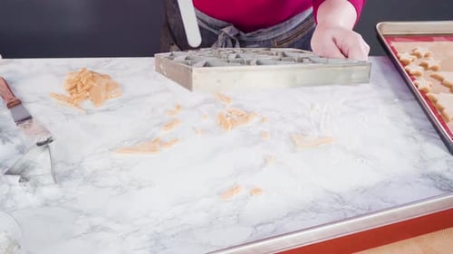 Woman Cuts Christmas Cookies and Reforms Dough Scraps
