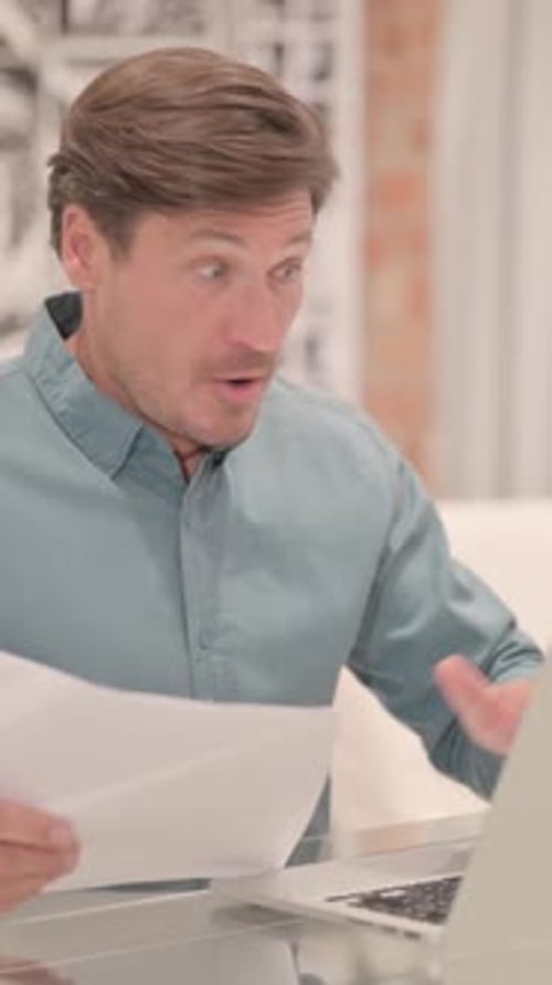 Man Reads Document and Reacts with Shock
