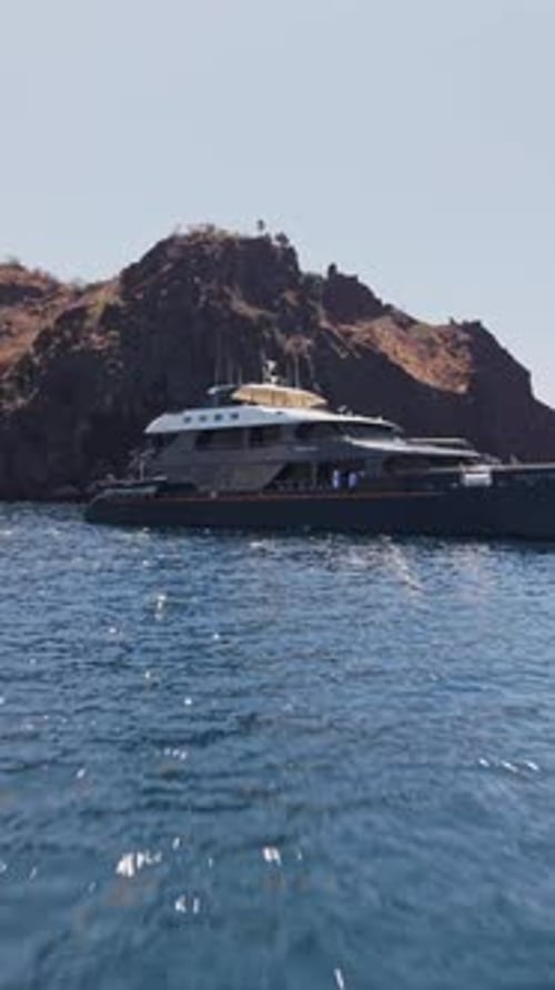 Paysage volcanique bordant un yacht immaculé ancré dans les eaux turquoises des Galapagos