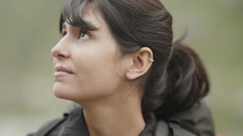 Close-up of Indian girl pausing during trek, visibly tired sweat on her face and heavy breathing