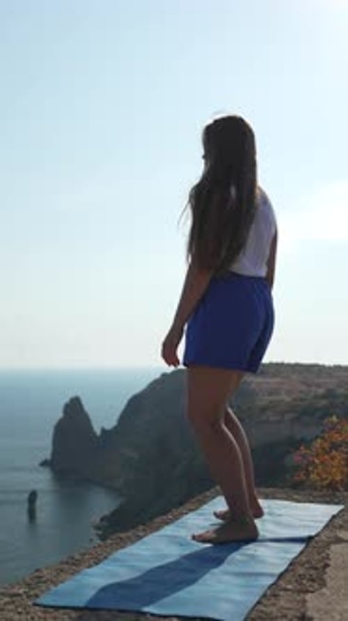 Yoga Cliff Ocean Young Woman Prepares for Workout on Scenic Mat in Morning Sun Enjoying Healthy