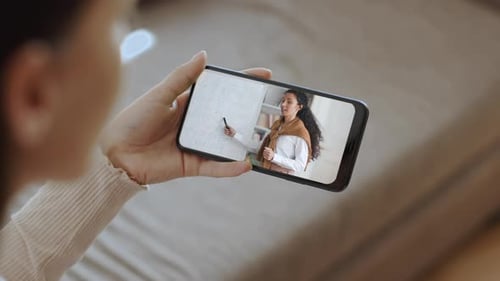 Person Holding Phone Watching Instructional Video