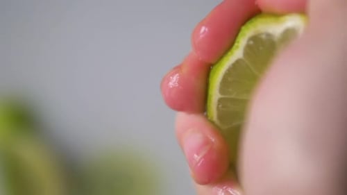 Woman is Squeezing a lime in Slowmotion. Filmed in ProRes.