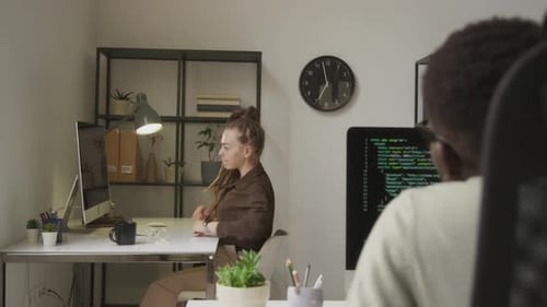 Jeune programmeuse étirant les bras en position assise au travail