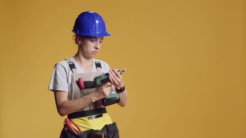 Female Constructor Working with Power Drill Electric Tool