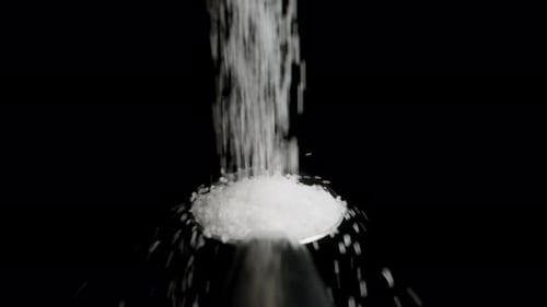 White Sugar Is Poured onto A Spoon in A Pile And Rolls Down. Slow Motion.