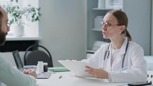 Female Doctor Reviewing Medical Records during Consultation with Patient