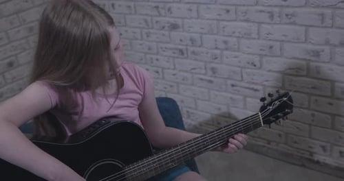 Girl Playing Acoustic Guitar at Home