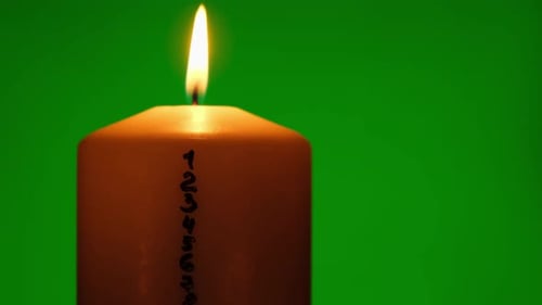 Candle with Advent Calendar on Green Chroma Key Background Traditional Burning Christmas Wax Candles