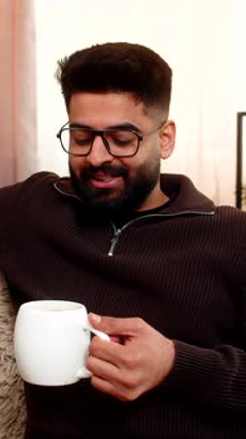 Man Relaxing on Couch with Mug of Drink