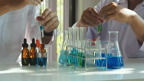 Researcher dropping the reagent or chemical liquid into test tube. Laboratory science, research.
