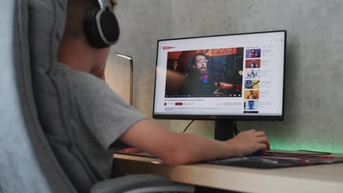 Teenager Watches Video on Personal Computer About Stock Trading