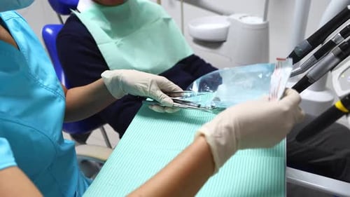 Dentist Assistant Preparing Sterilized Dental Instruments for Examination