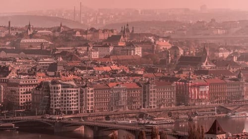 View from the Petrin hill in Prague. The orange haze hanging in the air above the city. Traffic is l