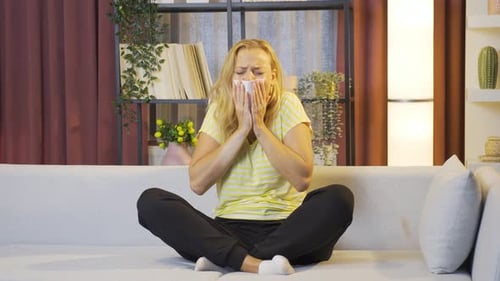 Femme se couvrant la bouche et le nez en toussant.