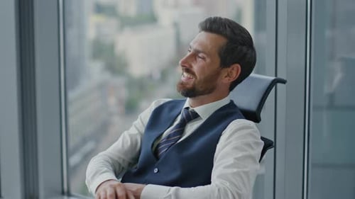 Successful bearded businessman smiling reading message on smartphone in modern office