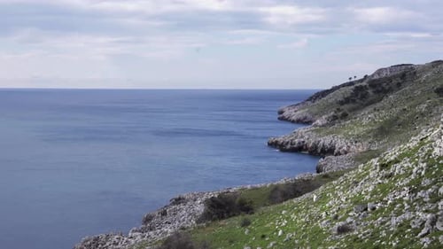 A steady shot of a beautiful rocky coastline on a summer day. Wonderful seascape with scenic sea wav