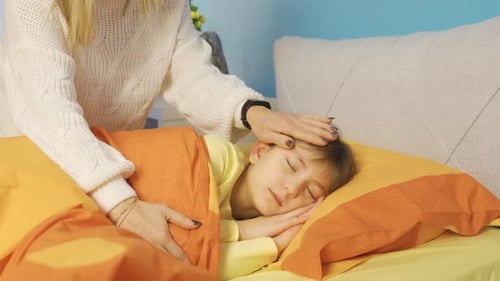 Loving mother covers her sleeping cute little daughter.