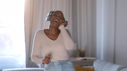 Woman with Headphones Dancing and Having Fun Indoors