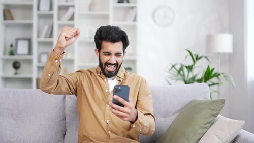 Excited Man Celebrates Good News on Smartphone