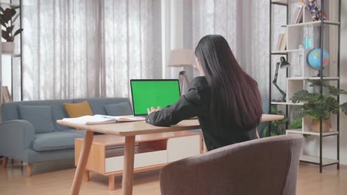 Asian Businesswoman Wearing Business Suit Typing On Green Screen Computer While Working At Home
