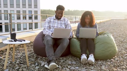 Young Adults Working on Laptops on Rooftop