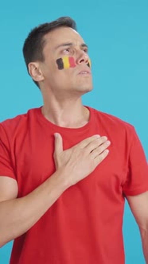 Man Listening to the Belgium National Anthem with Solemnity