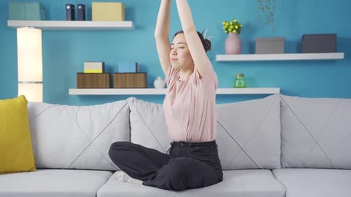 Woman Stretching Arms While Meditating on Couch