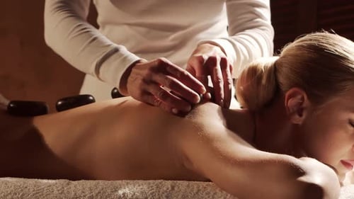 Woman is Getting Massage Treatment From the Therapist Massaging Procedure in Spa Healthcare