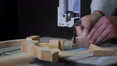 A man works with wood in a workshop. Working with wooden blanks. A man drills holes in wooden blanks