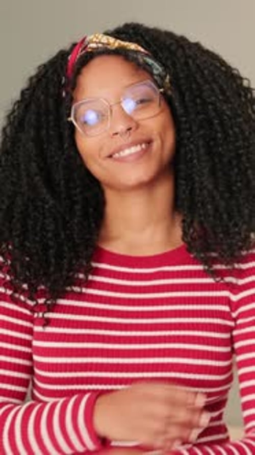 Smiling woman standing in the living room looking at the camera crossing her arms