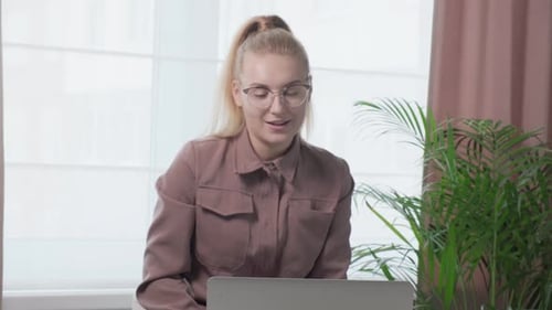 Young Woman Video Chatting with Laptop Computer
