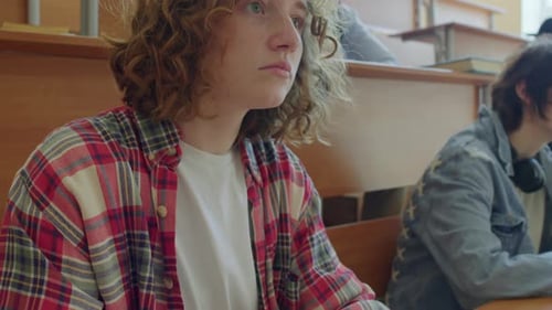 Student Taking Notes in University Classroom