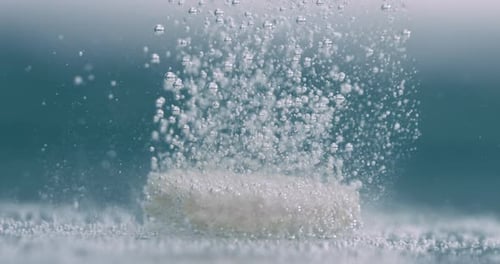 Extreme Close-up effervescent tablet, pill bubbling underwater. Shot on super slow motion camera