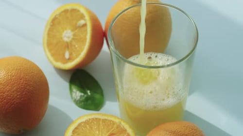 Pouring Fresh Orange Juice into Glass