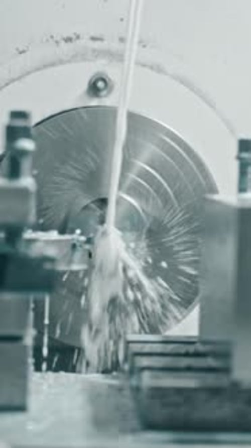 Cnc lathe machine in action with coolant flow for metal turning