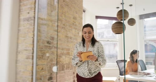 4k video footage of a businesswoman walking through the office using her digital tablet