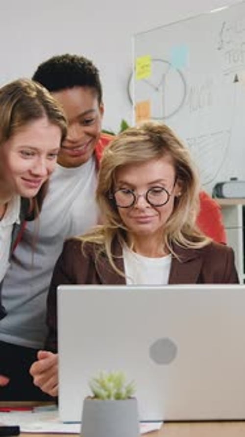 Three Women Looking at Laptop in Office Workplace