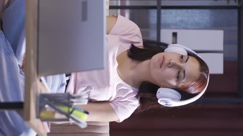 Young Woman Working at Laptop With Headphones
