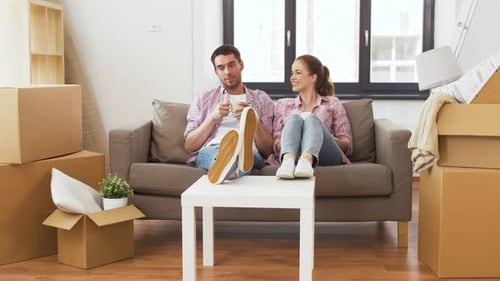 Happy young couple enjoying coffee break together in their new home
