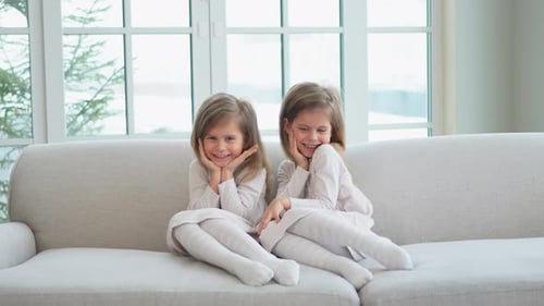Two Children Smiling Together on a Couch
