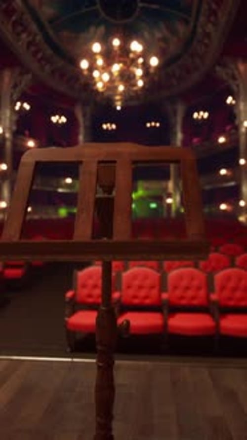 An Empty Theater with Red Seats and Chandeliers