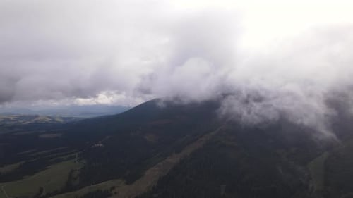 Aerial Footage Drone Flying Through Low Clouds in the Cloudy Weather Over Mountains