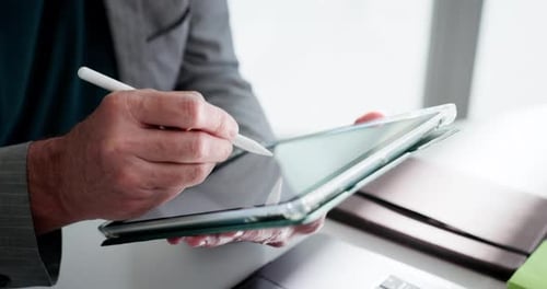 Man Uses Stylus on Tablet in Office