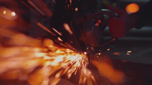 Metal Grinder Sparks Cutting Metal in Dark Workshop