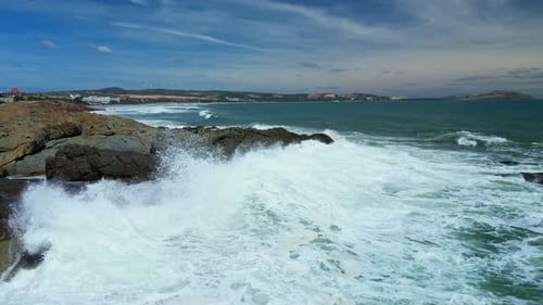 Aerial Slow Motion View of Waves Breaking Against Rocks on a Rocky Coastline Large Ocean Beautiful