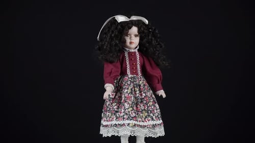 Rotating Curly Black Haired Doll On Black Background.