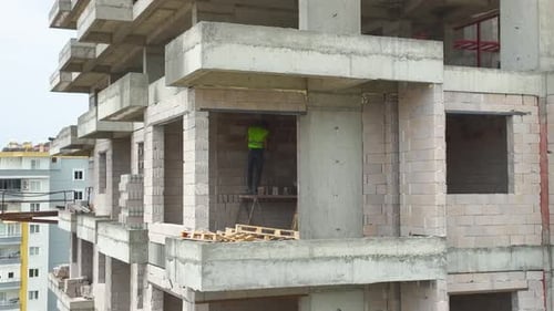Vídeo aéreo de trabajadores construyendo el techo de un complejo moderno