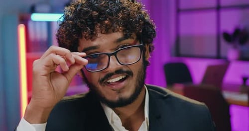 Close up portrait of man in glasses which looking at camera with sincerely smile in modern office