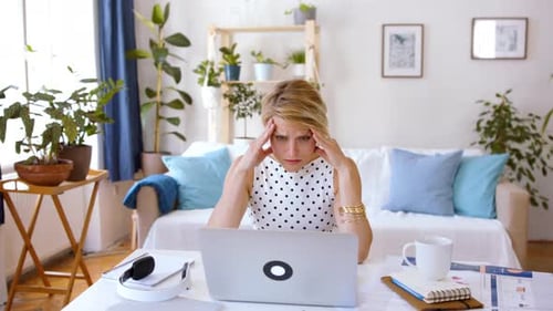 Frustrated Young Businesswoman with Laptop Indoors in Home Office Working